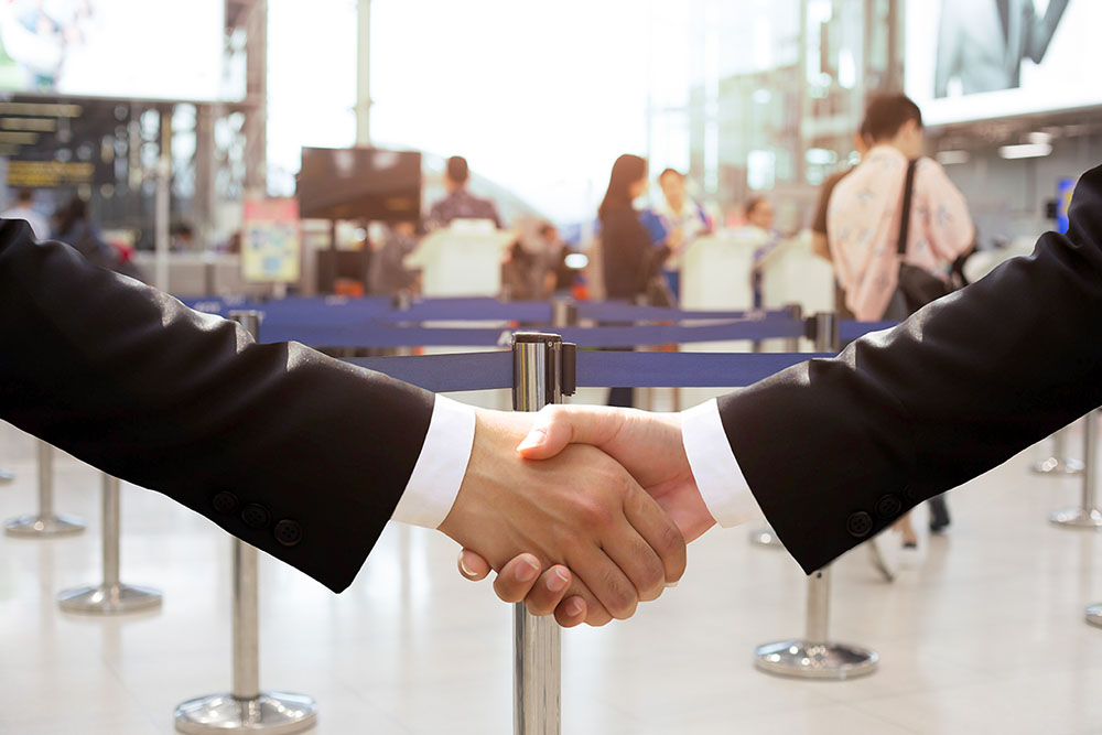 Business,Trip,Conceptual,Business,Hand,Shake,In,Airport,Building