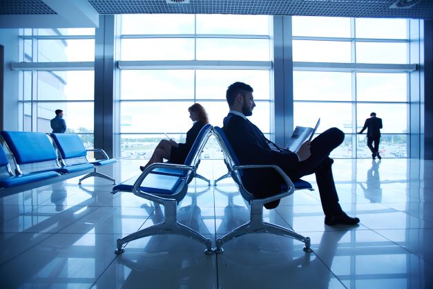 two-business-partners-reading-at-the-airport-on-background-of-their-colleagues-by-the-sbi-300726592