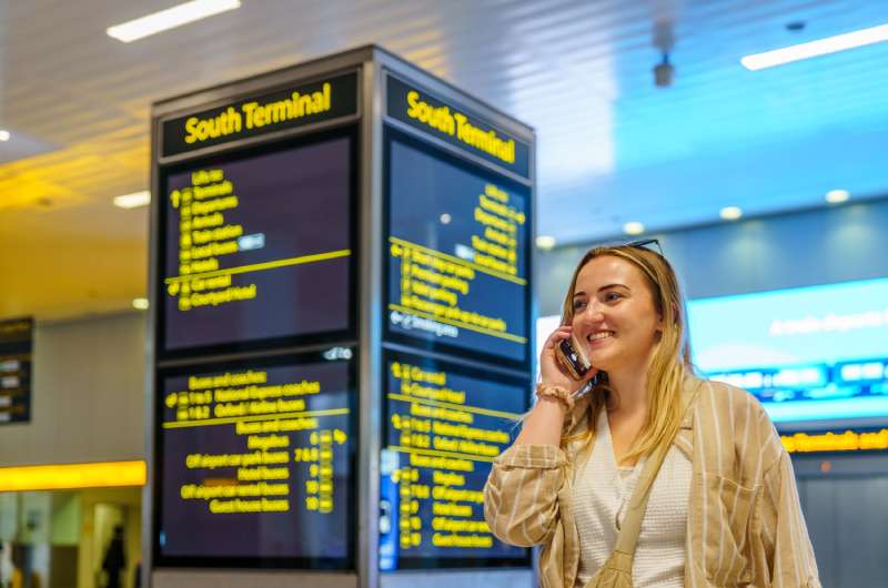 How Airport Meet and Greet Service Improve Airport Passenger Flow? 1 Traveler talking on her phone in a busy airport terminal